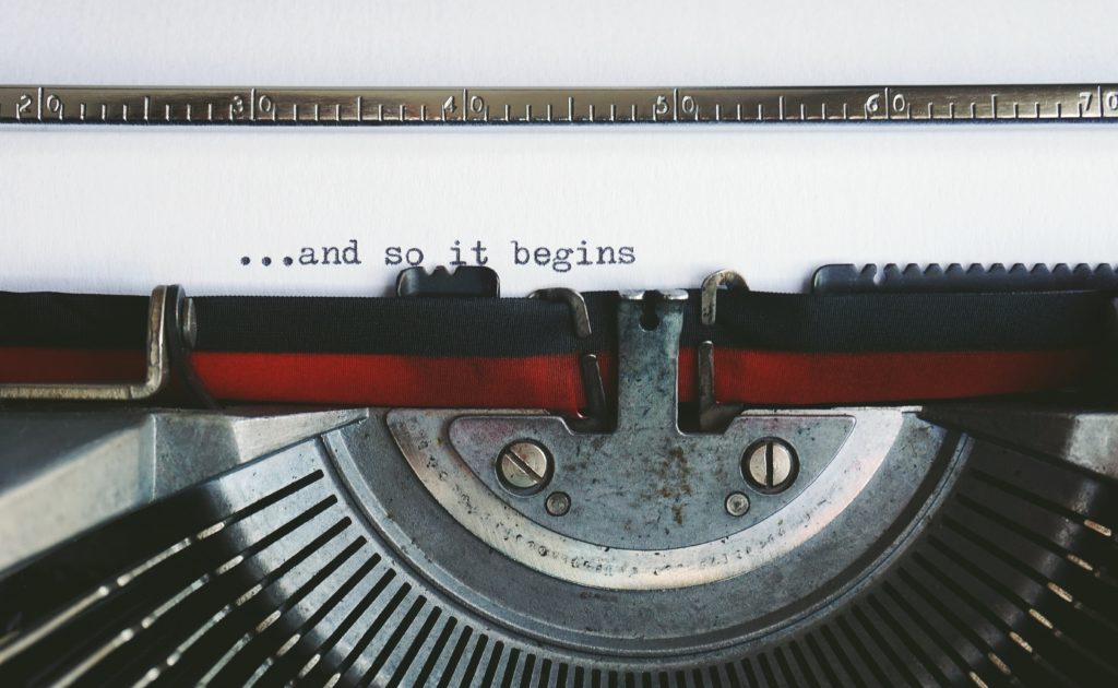 White and Black Braille Machine with the words "...and so it begins" written on a white sheet of paper